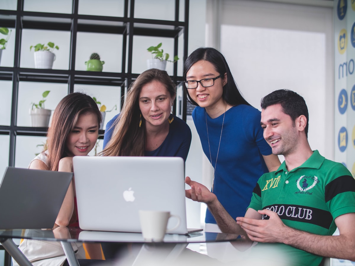 Team collaborating around a laptop